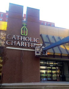 Workers install the exterior sign on Jan. 13 for the new Catholic Charities building at 850 Main Street. (Joe Cory/Key photo)
