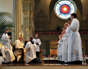 Bishop Robert W. Finn gives the seven men about to be ordained their final examination. (Kevin Kelly/Key photo)