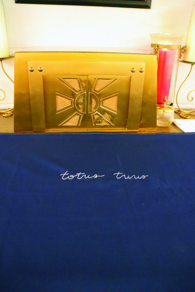 Close up of a golden tabernacle with an altar cloth embroidered with 'Totus Tuus' by a college student at the UMKC Newman Center chapel.